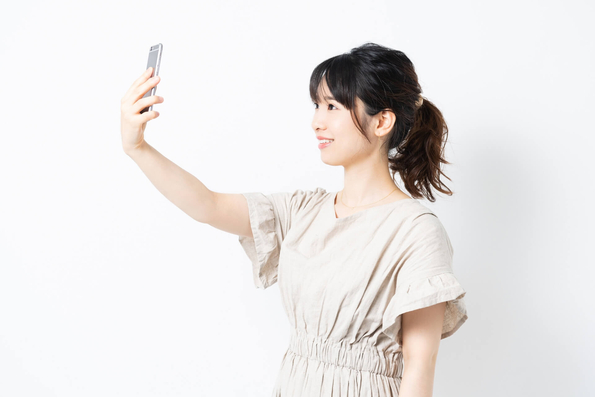 スマートフォンで自撮りする若い女性